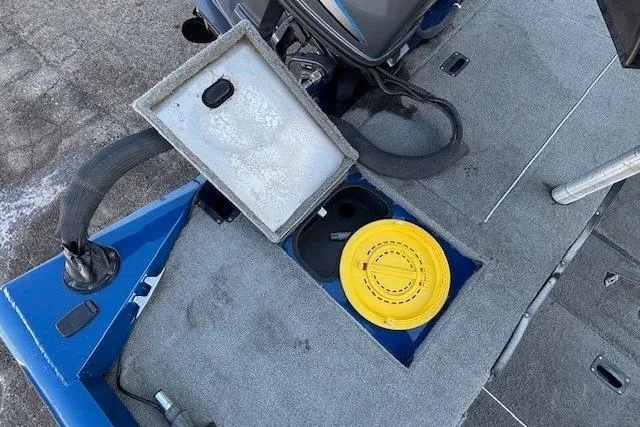 Slide: The Image of 2008 Triton TC-17 boat deck with open storage compartment and yellow lid. - 22