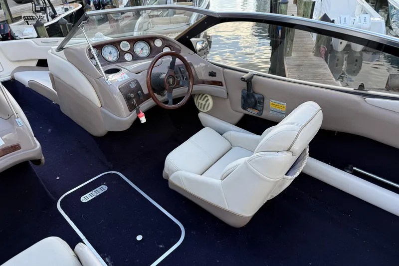 Slide: The Image of Interior of a 1999 Regal 1900 LSR boat with white seating and dashboard controls. - 13
