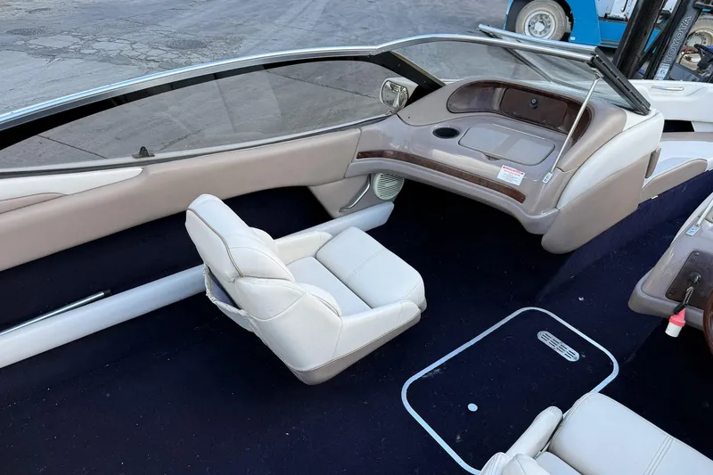 Slide: The Image of Interior of a 1999 Regal 1900 LSR boat with white seating and dashboard. - 15