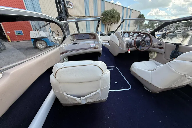 Slide: The Image of Interior of a 1999 Regal 1900 LSR boat with white seating and dashboard view. - 18