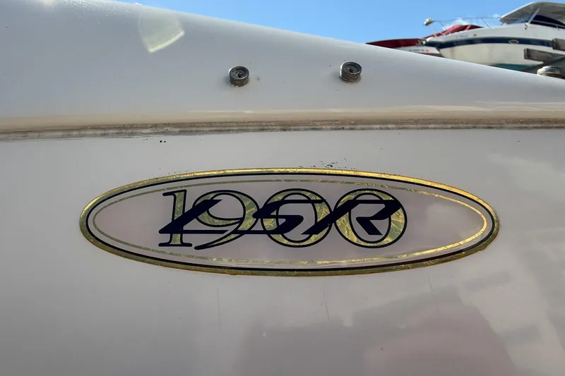 Slide: The Image of 1999 Regal 1900 LSR boat emblem with gold trim on white surface. - 27