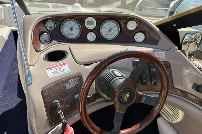 Slide: The Image of 1999 Regal 1900 LSR boat dashboard with gauges and wooden steering wheel. - 9