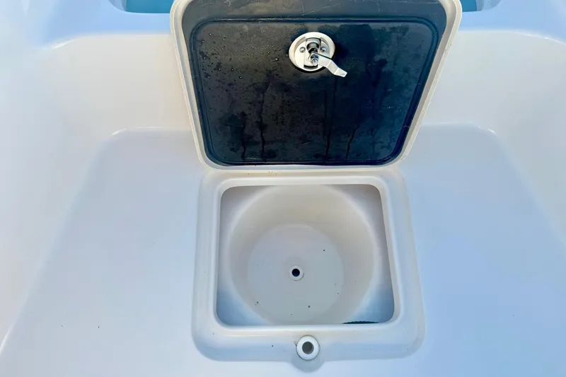 Slide: The Image of Key West 230 Bay Reef 2020 boat compartment with open hatch and drainage hole. - 16