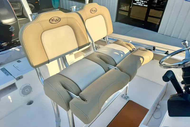 Slide: The Image of 2020 Key West 230 Bay Reef boat with beige cushioned seating and steering wheel. - 25