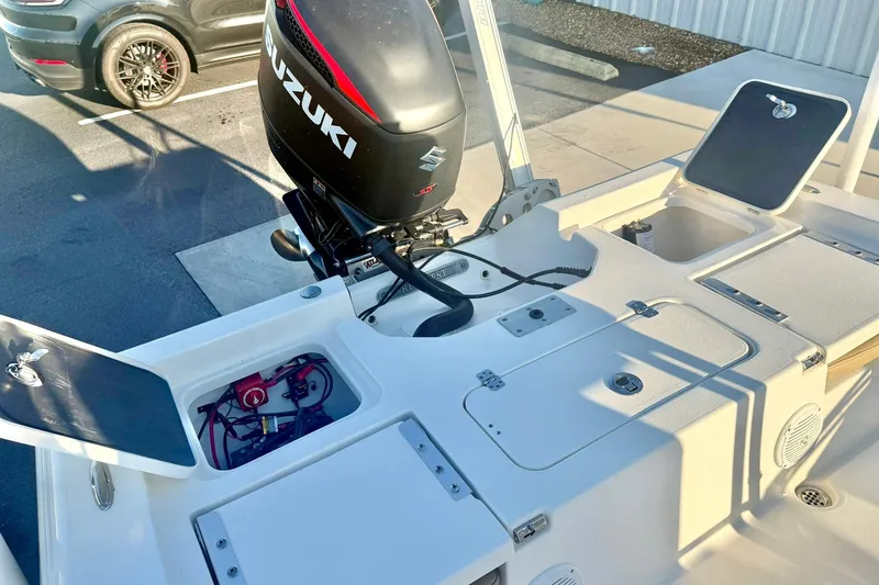 Slide: The Image of 2020 Key West 230 Bay Reef boat with Suzuki outboard motor and open storage compartments. - 31