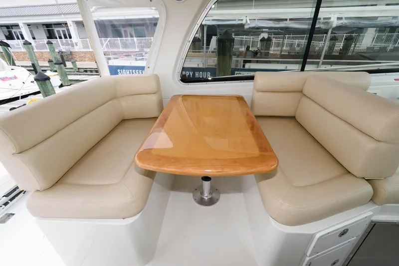 Slide: The Image of 2010 Back Cove 33 yacht interior with beige seating and wooden table. - 12