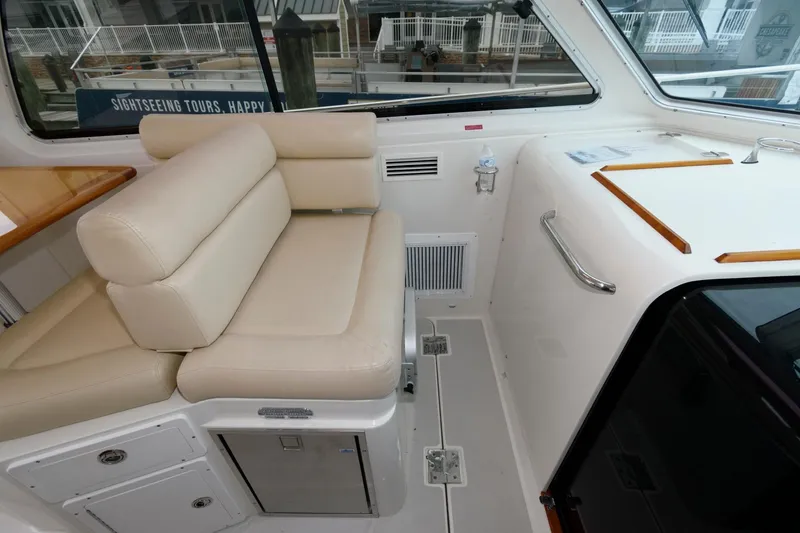 Slide: The Image of Interior of a 2010 Back Cove 33 boat with beige seating and storage compartments. - 19