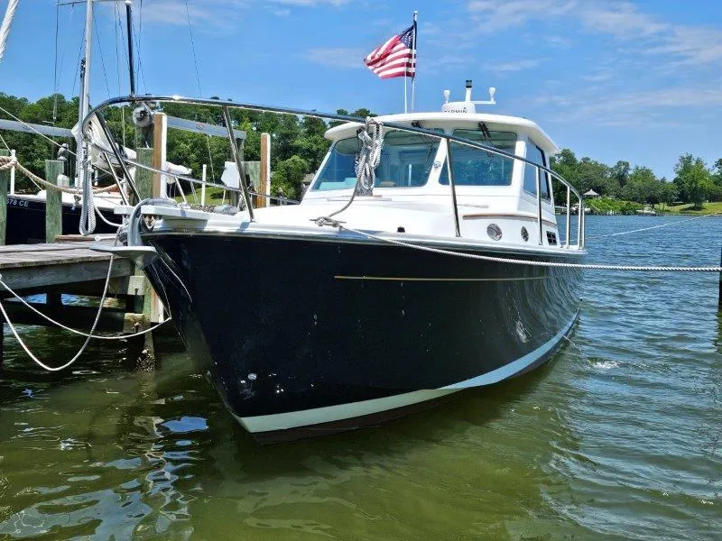 Slide: The Image of 2010 Back Cove 33 boat docked on a sunny day with American flag. - 2