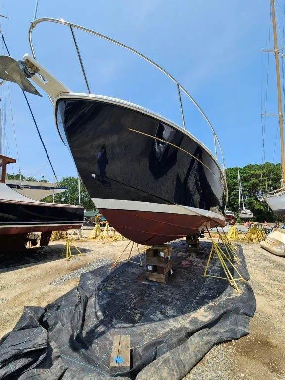 Slide: The Image of 2010 Back Cove 33 boat on dry dock, black hull, sunny day. - 5