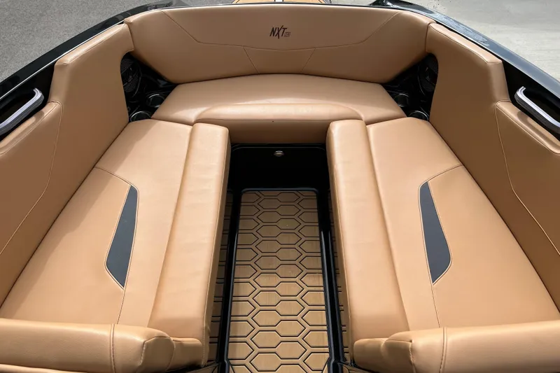 Slide: The Image of 2023 MasterCraft NXT24 boat interior with tan leather seating and hexagonal floor design. - 11