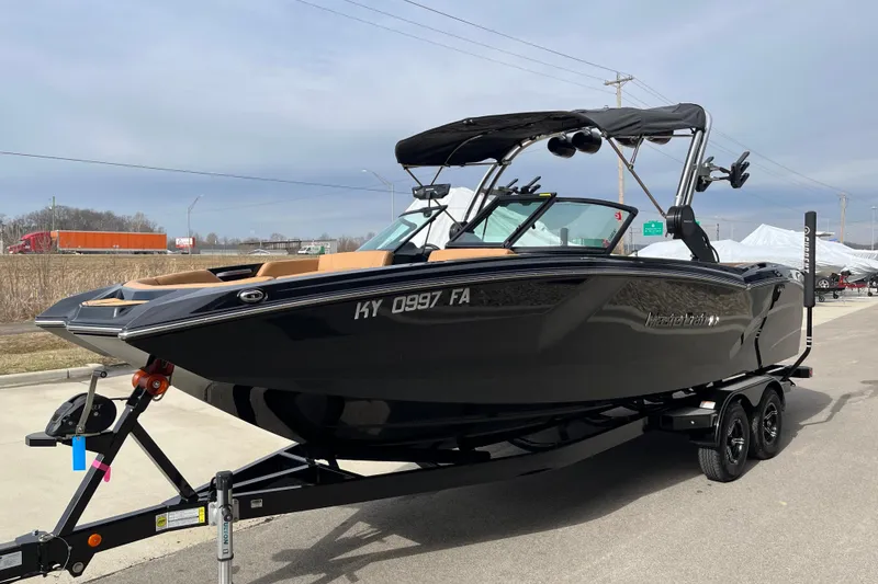 Slide: The Image of 2023 MasterCraft NXT24 boat on trailer, sleek black design, parked outdoors. - 5