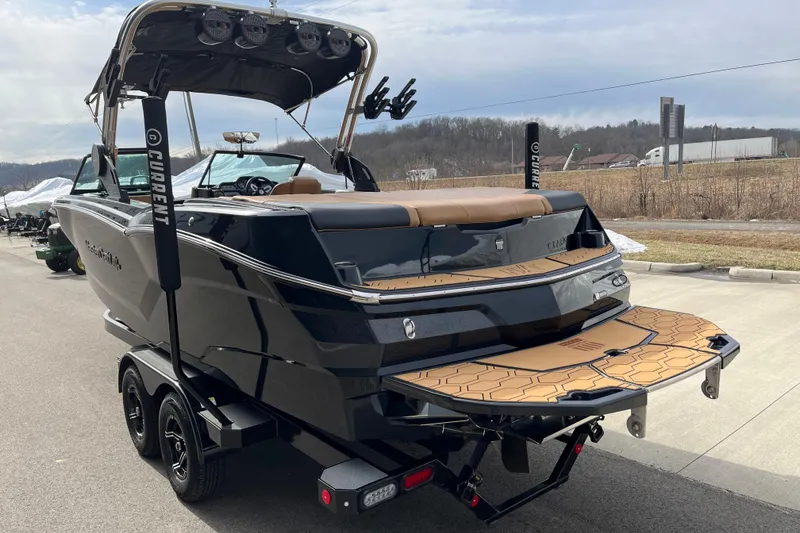 Slide: The Image of 2023 MasterCraft NXT24 boat on trailer, sleek black design, outdoor setting. - 6