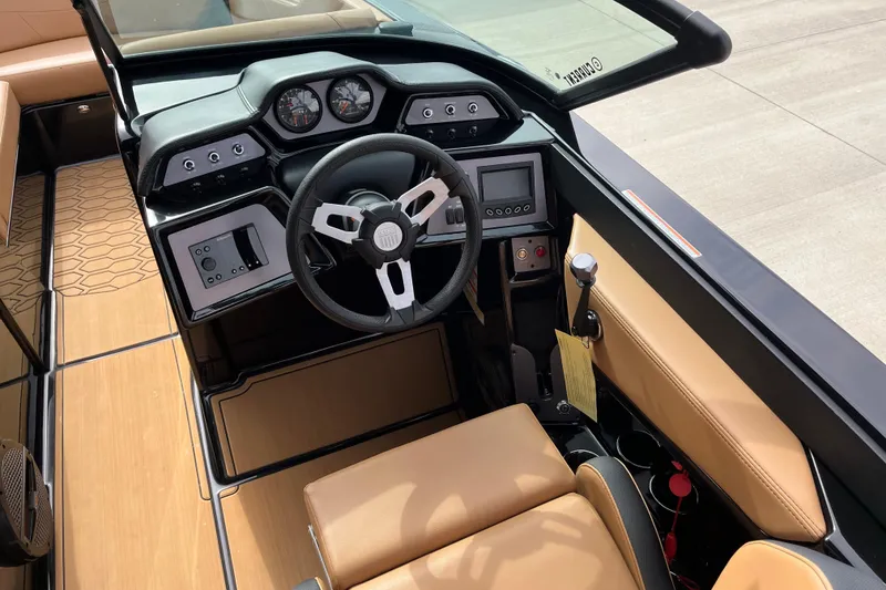 Slide: The Image of 2023 MasterCraft NXT24 boat interior with modern dashboard and tan seating. - 9