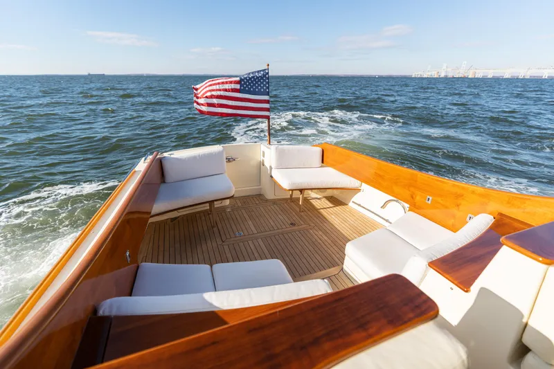 Slide: The Image of Hinckley Talaria 44 MKII Express 2010 yacht with American flag on open sea. - 11