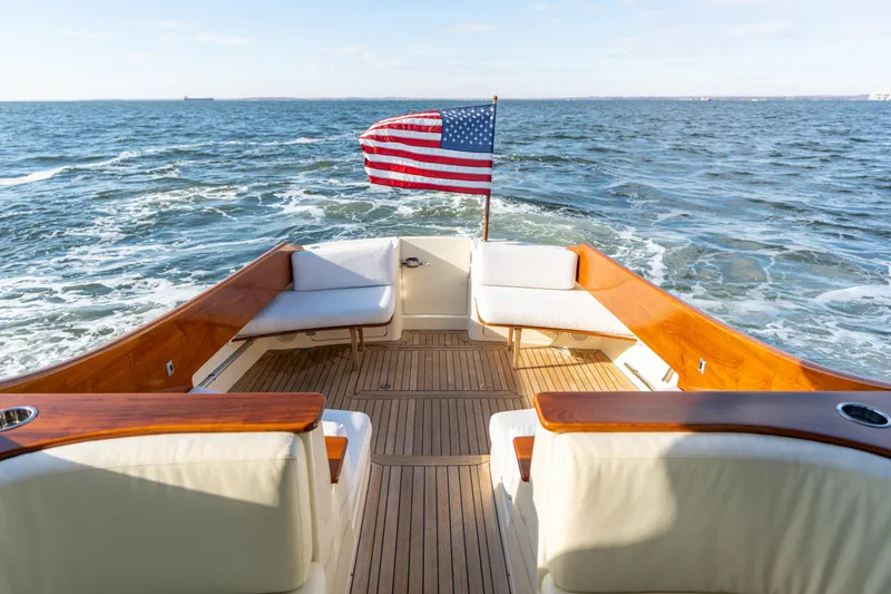 Slide: The Image of Hinckley Talaria 44 MKII Express 2010 yacht with American flag, cruising on open water. - 14