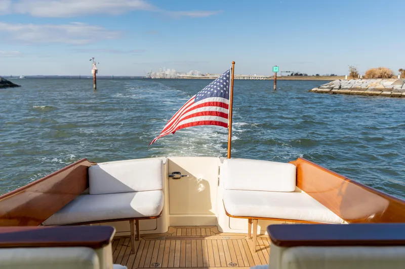 Slide: The Image of Hinckley Talaria 44 MKII Express 2010 yacht with American flag on open water. - 15