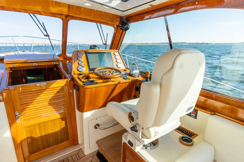 Slide: The Image of Helm of 2010 Hinckley Talaria 44 MKII Express yacht with wooden dashboard and white captain's chair. - 29
