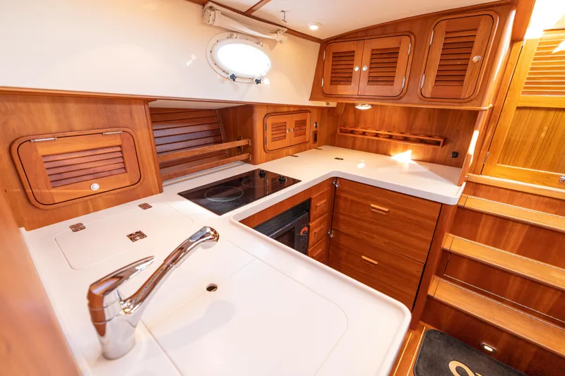 Slide: The Image of Luxurious 2010 Hinckley Talaria 44 MKII Express yacht kitchen with wood cabinetry and modern amenities. - 41