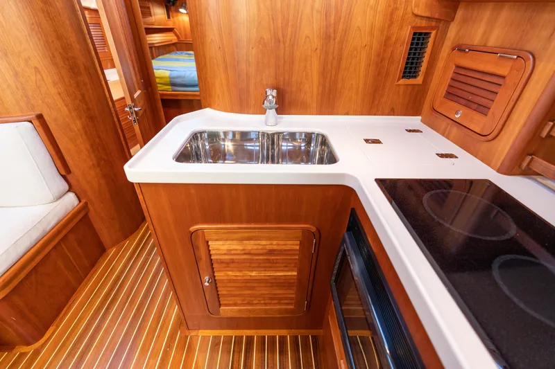 Slide: The Image of Luxurious 2010 Hinckley Talaria 44 MKII Express yacht interior with wooden cabinetry and modern kitchen amenities. - 42