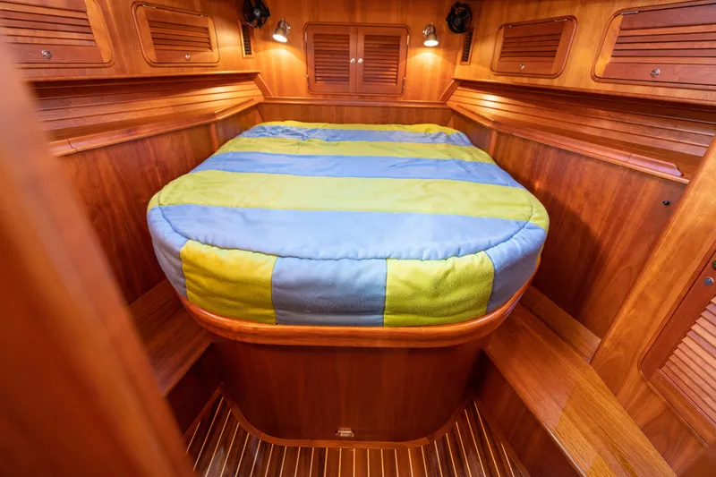 Slide: The Image of 2010 Hinckley Talaria 44 MKII Express cabin with wooden interior and colorful bedding. - 43