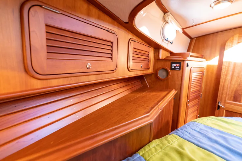 Slide: The Image of Interior of 2010 Hinckley Talaria 44 MKII Express, featuring wooden cabinetry and cozy sleeping area. - 45