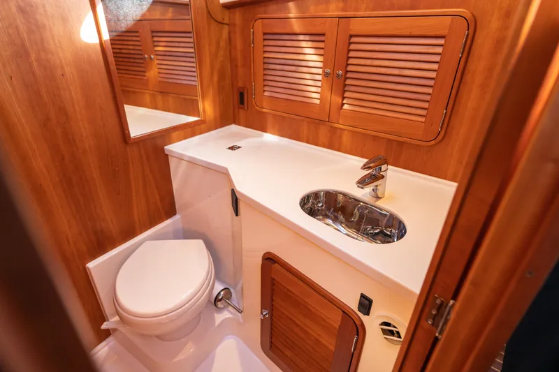 Slide: The Image of Luxurious 2010 Hinckley Talaria 44 MKII Express yacht bathroom with wooden cabinetry and modern fixtures. - 46