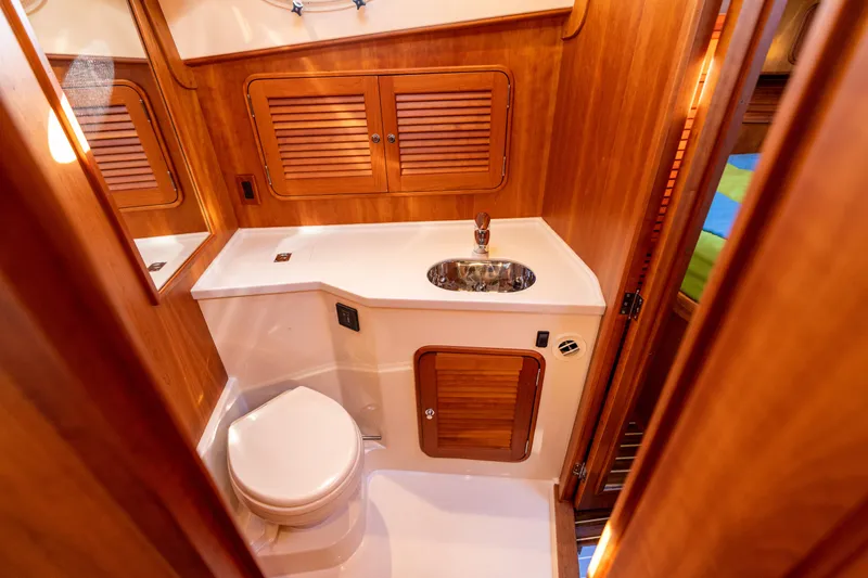 Slide: The Image of Luxurious 2010 Hinckley Talaria 44 MKII Express yacht bathroom with wooden cabinetry and modern fixtures. - 47
