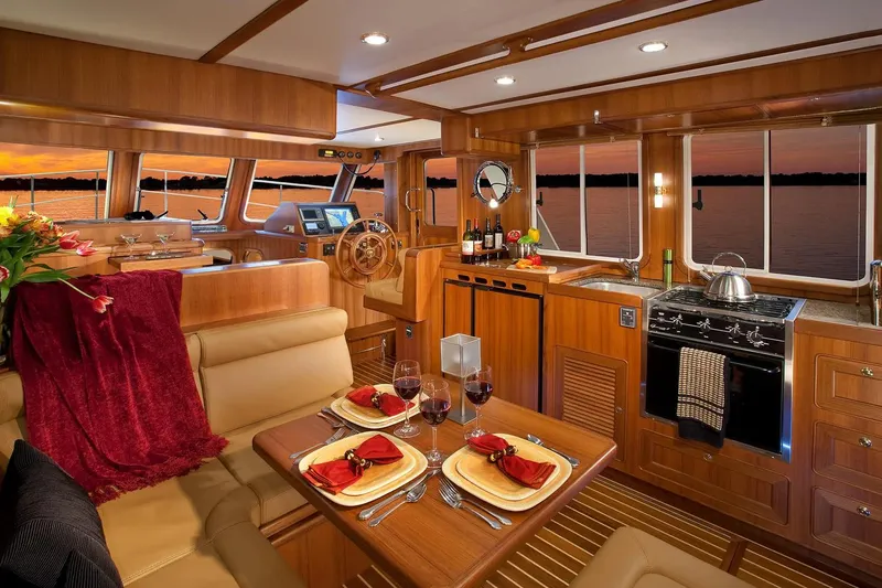Slide: The Image of Luxurious interior of 2025 Helmsman Trawlers 38 Sedan with elegant dining setup at sunset. - 16