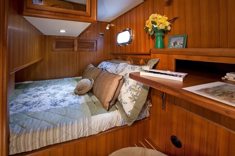 Slide: The Image of Cozy cabin interior of 2025 Helmsman Trawlers 38 Sedan with wood paneling and floral decor. - 24