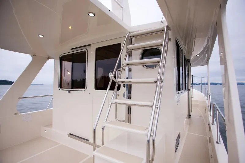 Slide: The Image of 2025 Helmsman Trawlers 38 Sedan yacht, exterior view with ladder and windows. - 7