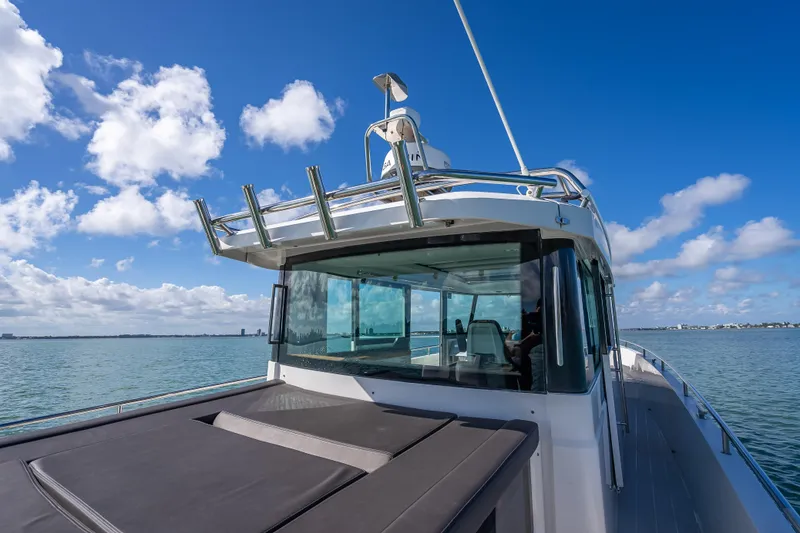 Slide: The Image of 2017 Axopar 37 XC Cross Cabin boat on calm water under blue sky. - 22
