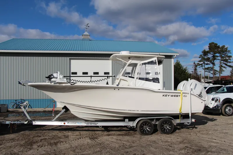 The Image of 2024 Key West 244 Center Console boat on trailer, parked near a building. - 0