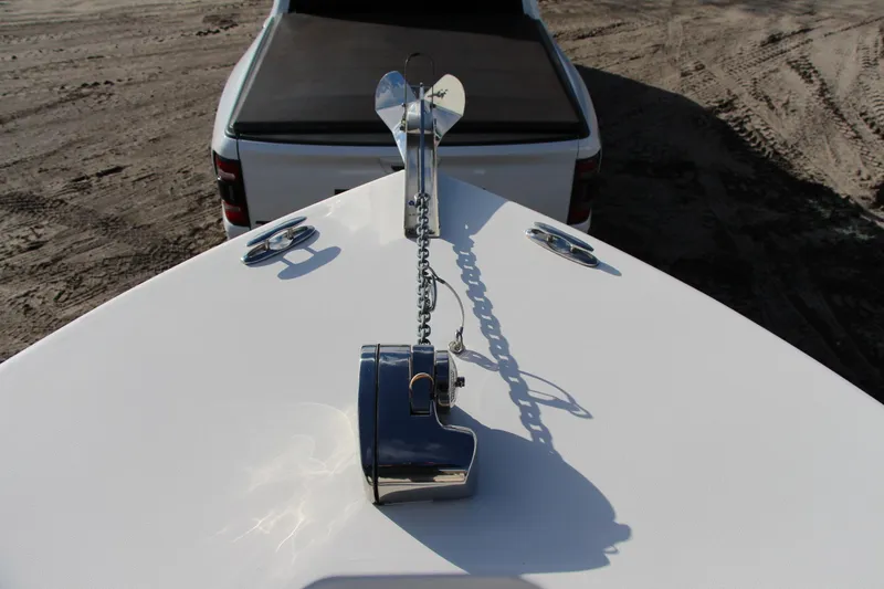 Slide: The Image of 2024 Key West 244 Center Console boat with anchor, parked on sandy terrain. - 14