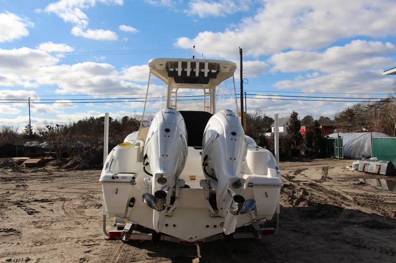 Slide: The Image of 2024 Key West 244 Center Console boat with dual outboard engines on sandy terrain. - 3