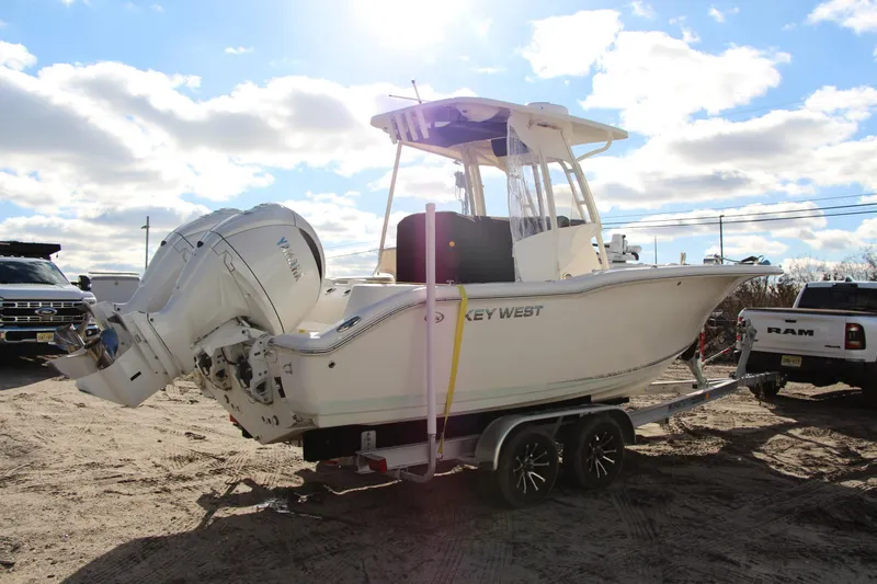 Slide: The Image of 2024 Key West 244 Center Console boat on trailer, parked outdoors under a cloudy sky. - 4