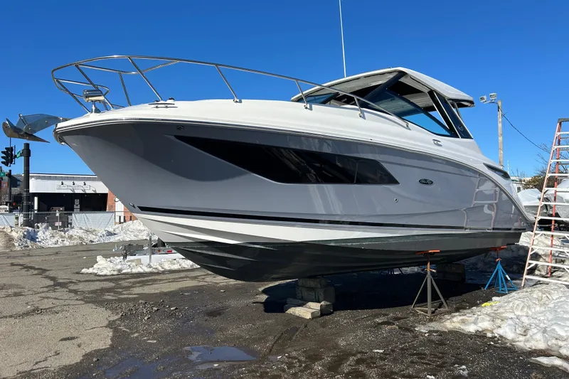 Slide: The Image of 2021 Sea Ray Sundancer 320 boat on land, surrounded by snow, under clear blue sky. - 1
