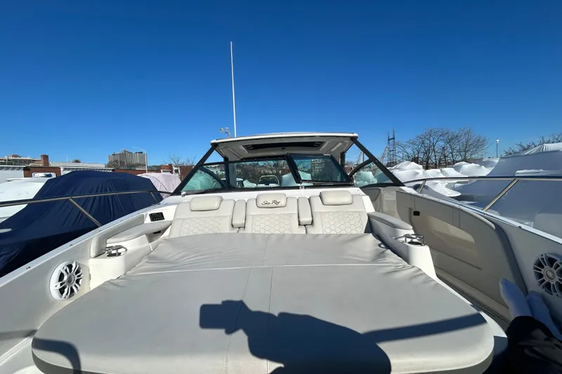 Slide: The Image of 2021 Sea Ray Sundancer 320 boat with spacious deck and luxurious seating under clear blue sky. - 11