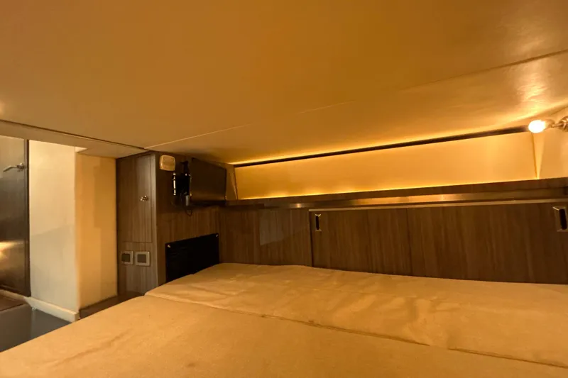 Slide: The Image of 2021 Sea Ray Sundancer 320 cabin interior with cozy lighting and wood paneling. - 17