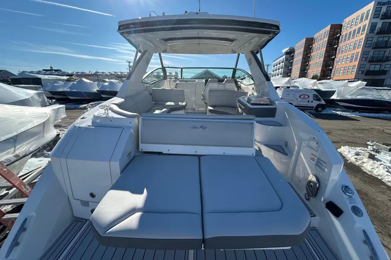 Slide: The Image of 2021 Sea Ray Sundancer 320 yacht with spacious seating, docked under clear blue skies. - 2
