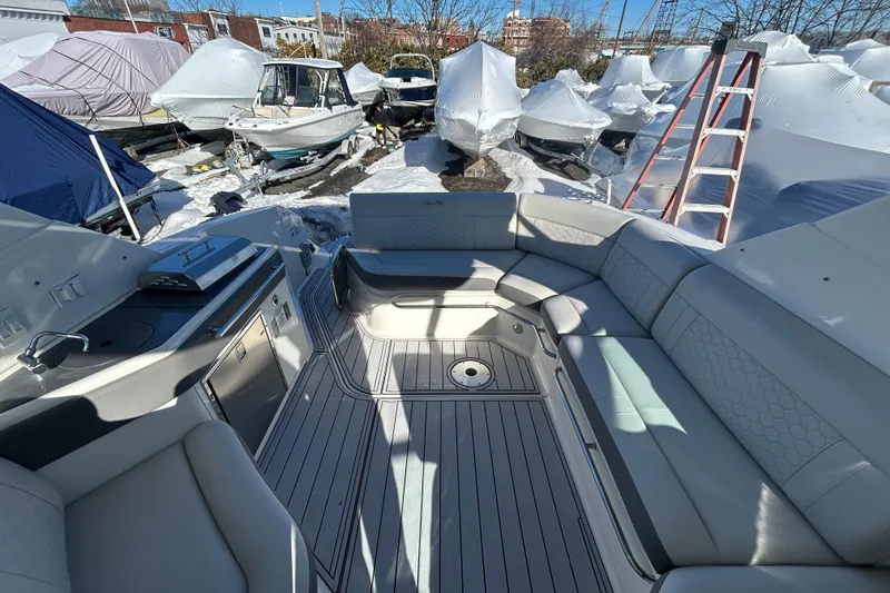 Slide: The Image of 2021 Sea Ray Sundancer 320 interior with seating, docked among covered boats. - 4