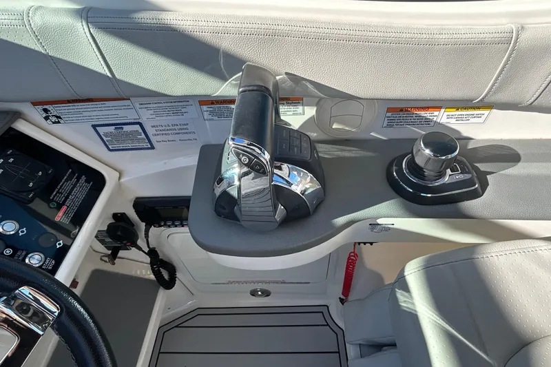 Slide: The Image of 2021 Sea Ray Sundancer 320 helm controls with joystick and throttle levers. - 8