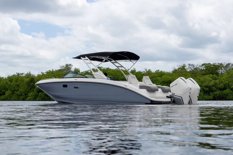 Slide: The Image of 2026 Sea Ray SDX 290 Outboard on calm water with green backdrop. - 1