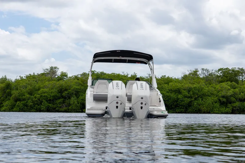 Slide: The Image of Sea Ray SDX 290 Outboard 2026 on calm water with green backdrop. - 22
