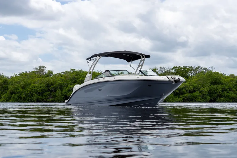 Slide: The Image of 2026 Sea Ray SDX 290 Outboard on calm water with green backdrop. - 26