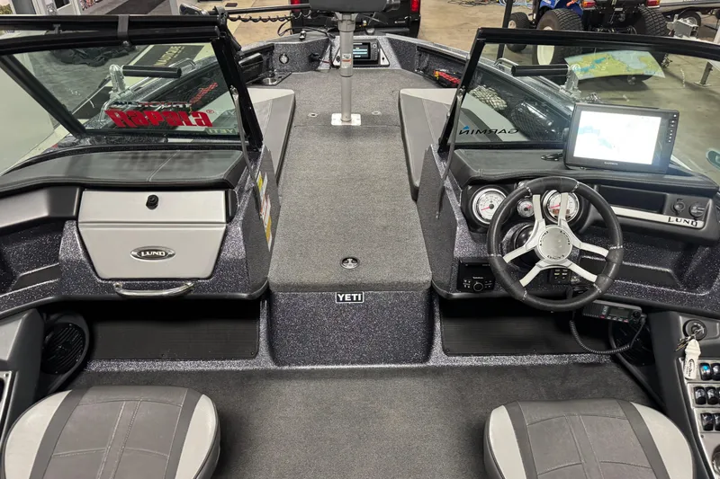 Slide: The Image of 2022 Lund 202 Pro-V GL boat interior with steering wheel and dashboard controls. - 11