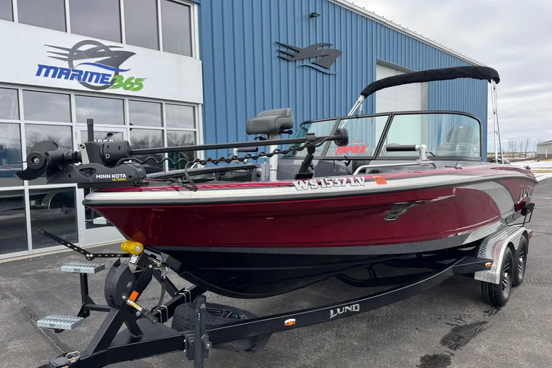 Slide: The Image of 2022 Lund 202 Pro-V GL boat in red, parked outside Marine 365 building. - 2