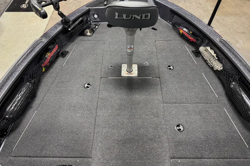 Slide: The Image of 2022 Lund 202 Pro-V GL boat interior with gray carpet and storage compartments. - 21