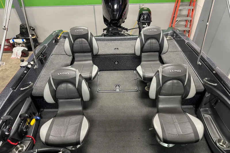 Slide: The Image of 2022 Lund 202 Pro-V GL boat interior with four gray seats and a motor. - 26