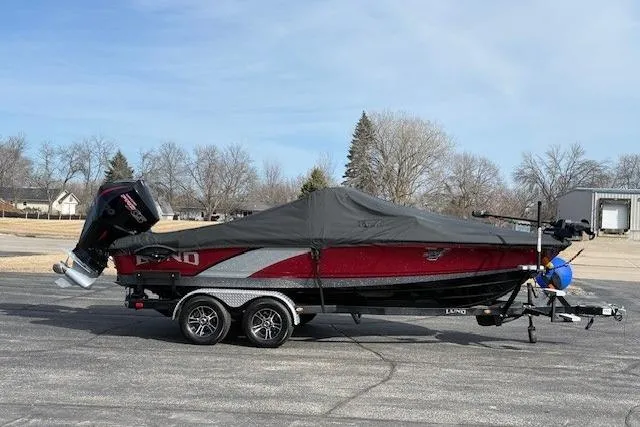 Slide: The Image of 2022 Lund 202 Pro-V GL boat with cover on trailer, parked outdoors. - 33