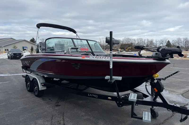 Slide: The Image of 2022 Lund 202 Pro-V GL boat on trailer in parking lot, overcast sky. - 5